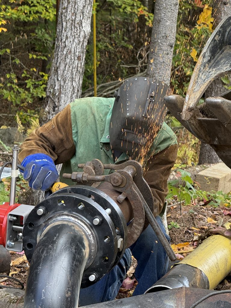 A construction working cutting pipe
