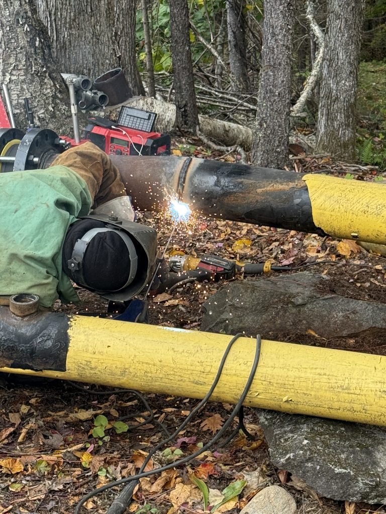 Construction worker welding pipes together
