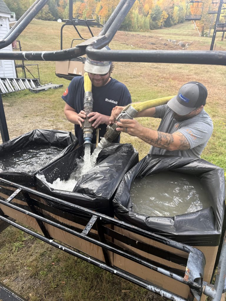 Two guys filling boxes with water