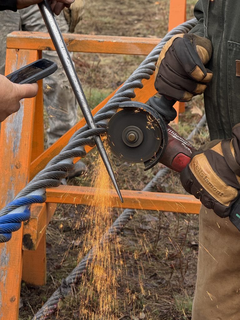 Workers cutting a steel cable